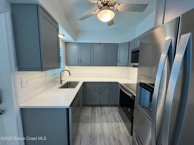 a kitchen with a sink refrigerator and cabinets