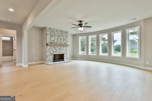 a view of an empty room with a fireplace and a window