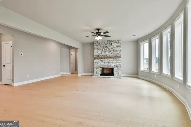 a view of an empty room with a fireplace and a window