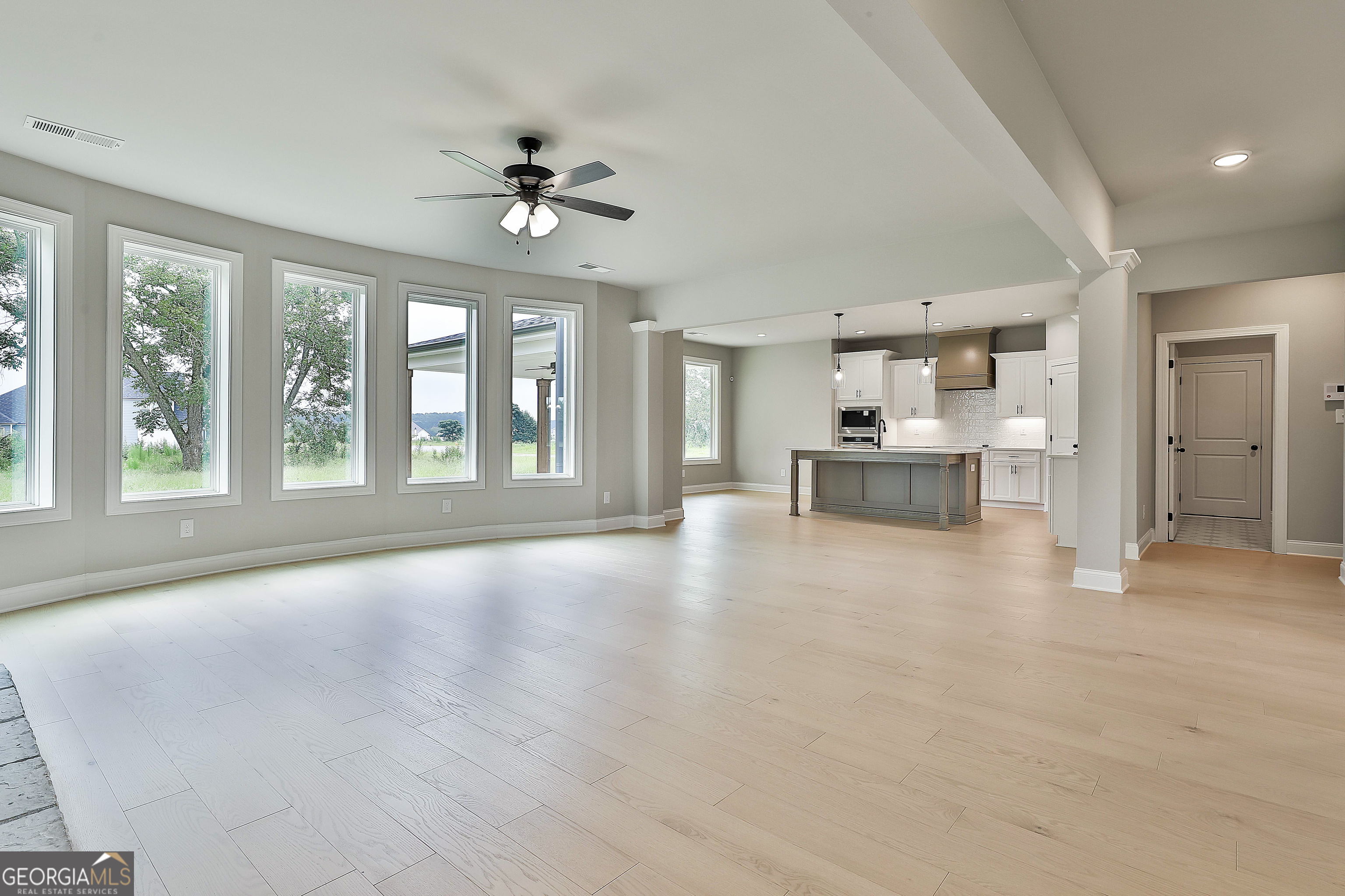 291 Grove Park, Unit 90 Senoia, GA 30276 - Photo 18 of 53 a view of an empty room with a window and wooden floor