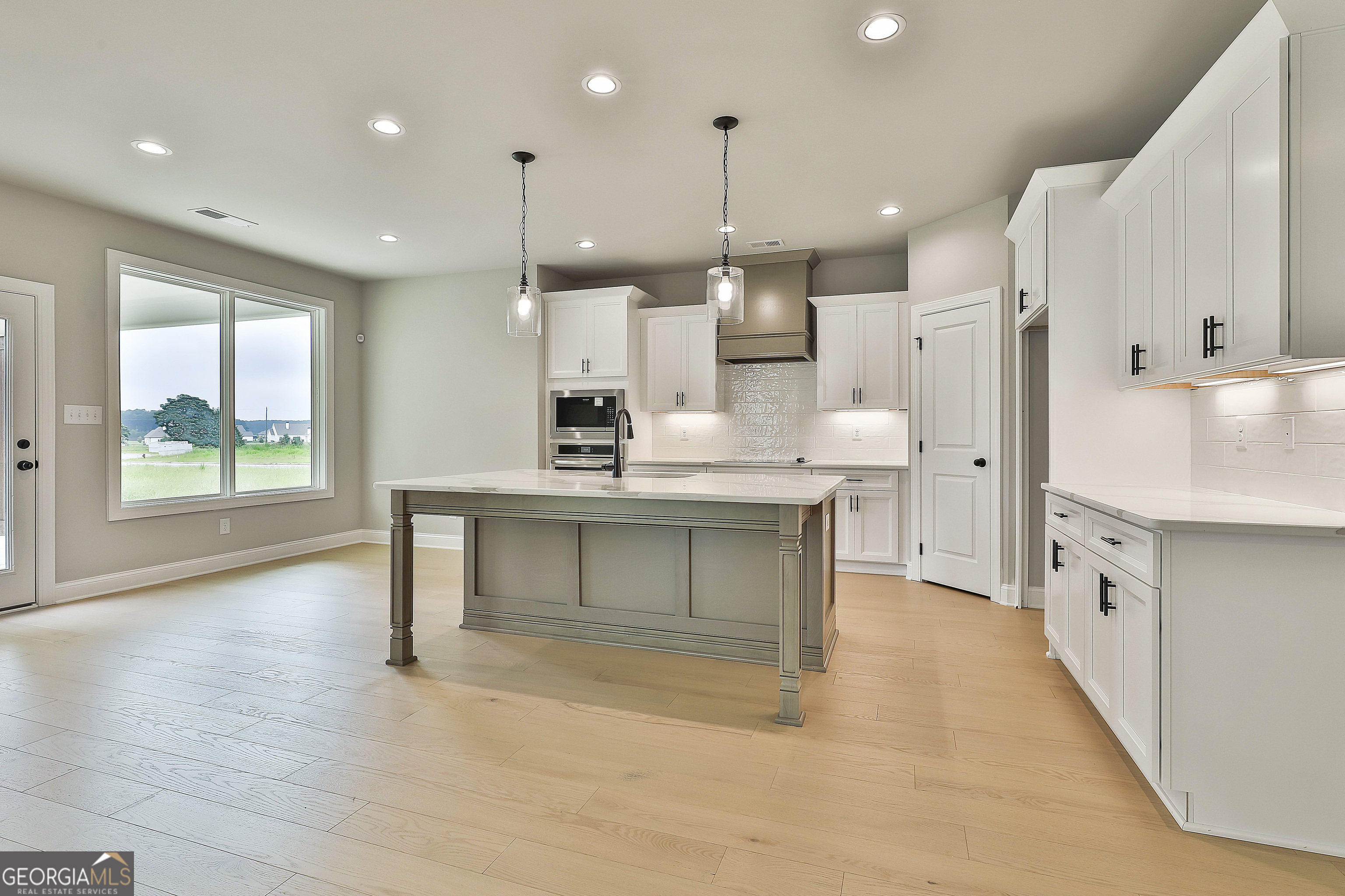 291 Grove Park, Unit 90 Senoia, GA 30276 - Photo 19 of 53 a large white kitchen with a large window and stainless steel appliances
