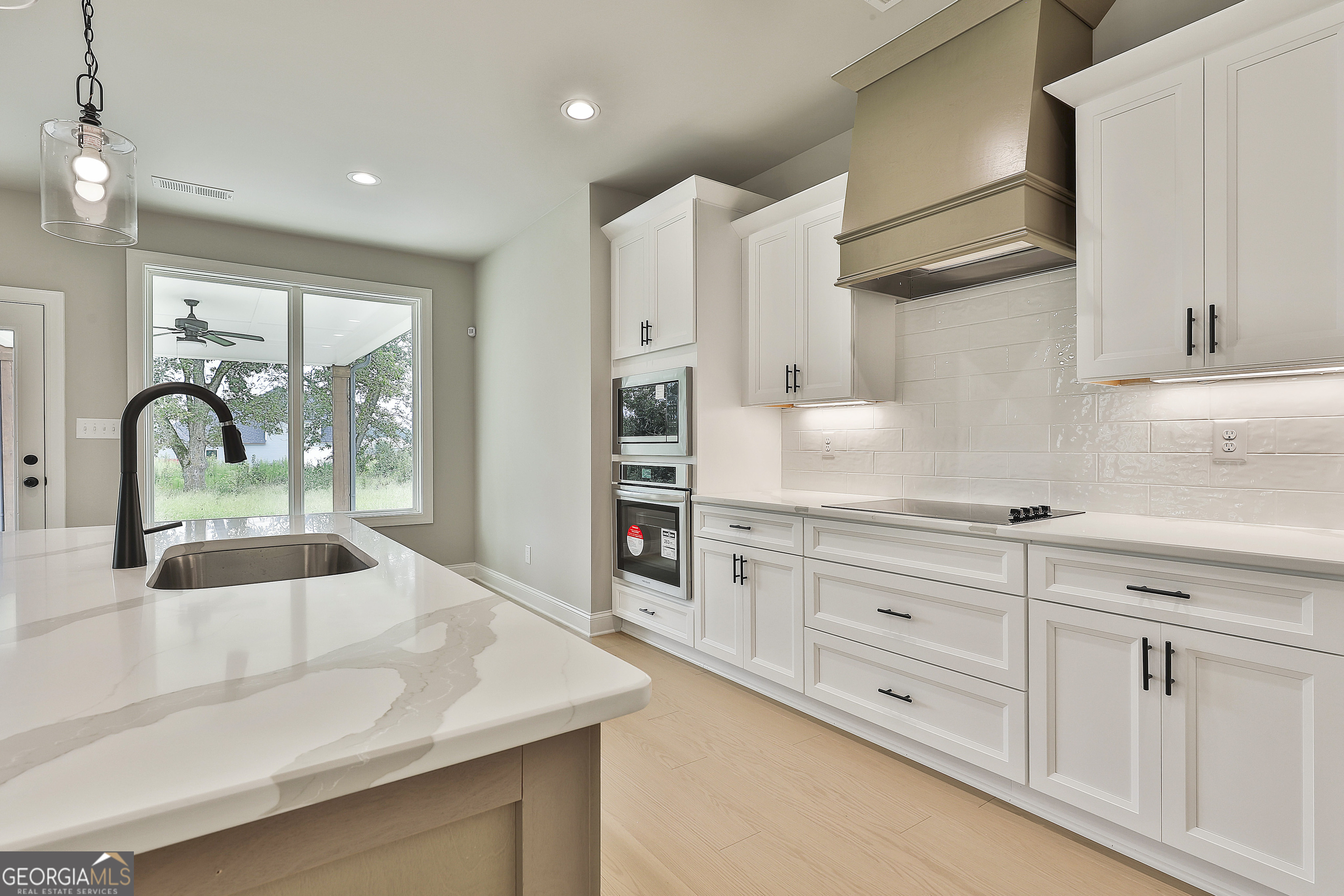291 Grove Park, Unit 90 Senoia, GA 30276 - Photo 21 of 53 a kitchen with granite countertop white cabinets and a sink