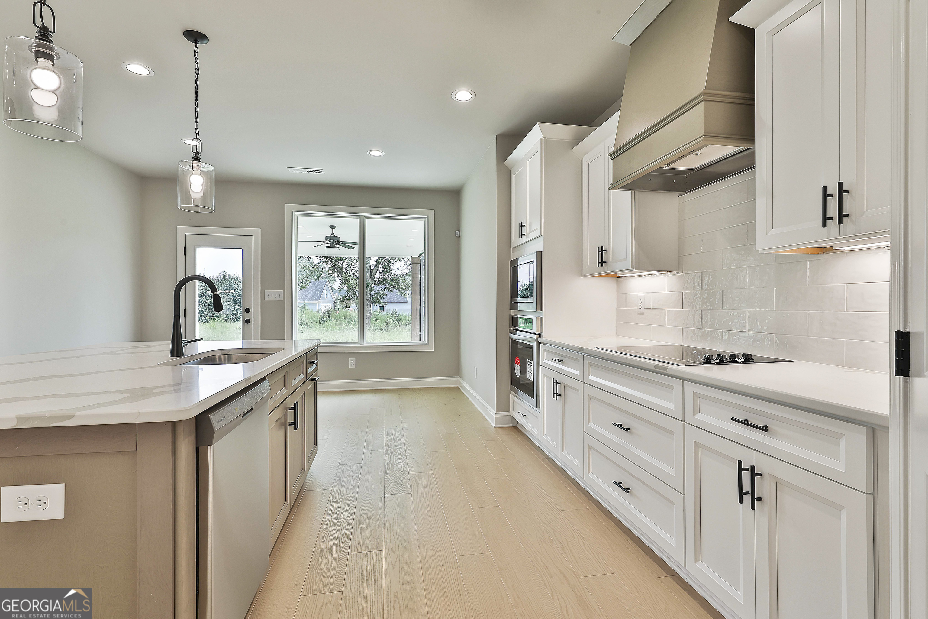 291 Grove Park, Unit 90 Senoia, GA 30276 - Photo 22 of 53 a kitchen with stainless steel appliances granite countertop a sink a stove and a wooden floors