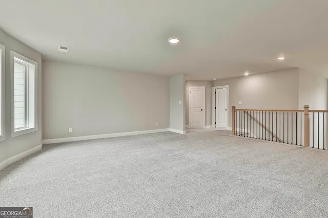 a view of a big room with windows and chandelier fan