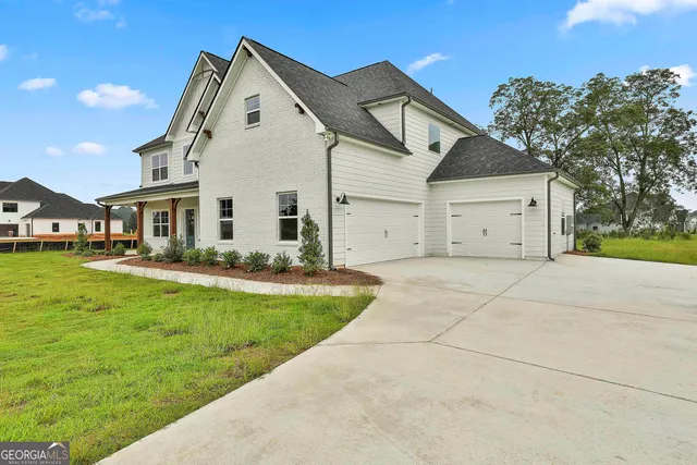 a view of a white house with a big yard and large trees