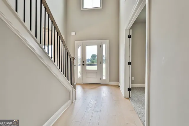 a view of a hallway with wooden floor and staircase