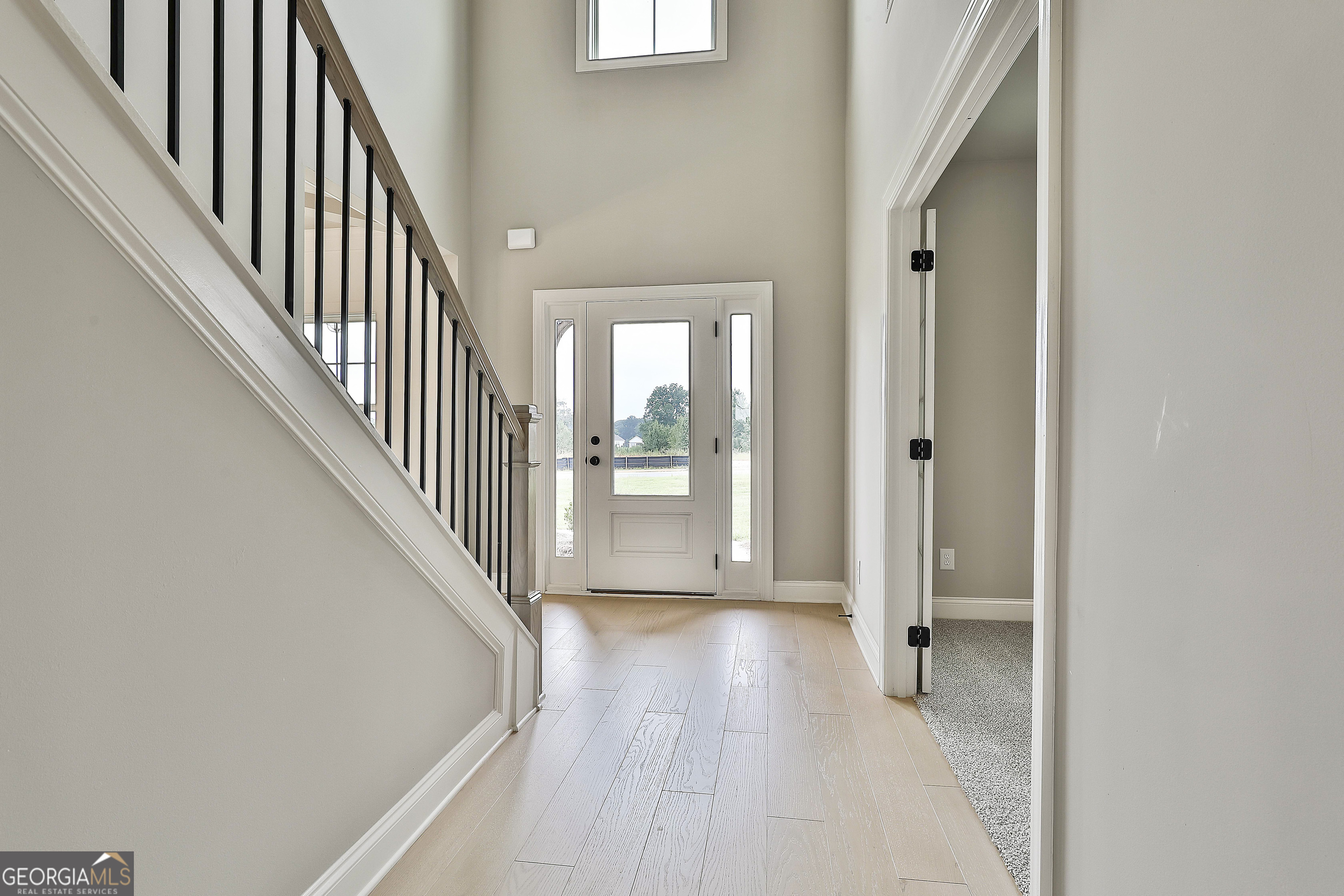 291 Grove Park, Unit 90 Senoia, GA 30276 - Photo 8 of 53 a view of a hallway with wooden floor and staircase