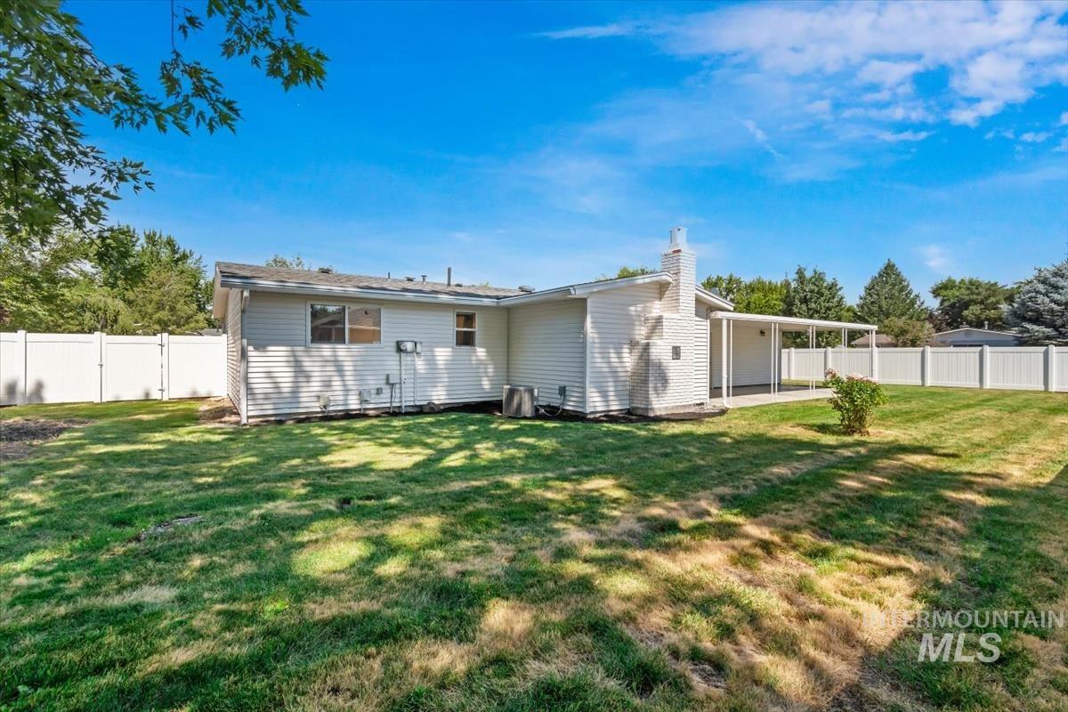 2217 North Middlefield Road Boise, ID 83704 - Photo 32 of 34 Expansive backyard featuring a lush lawn, white privacy fencing, and a covered patio structure