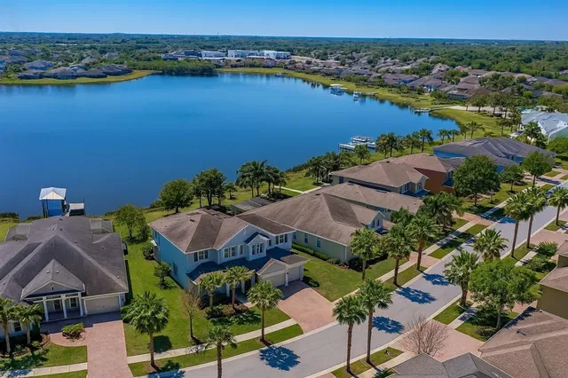 an aerial view of ocean and residential houses with outdoor space