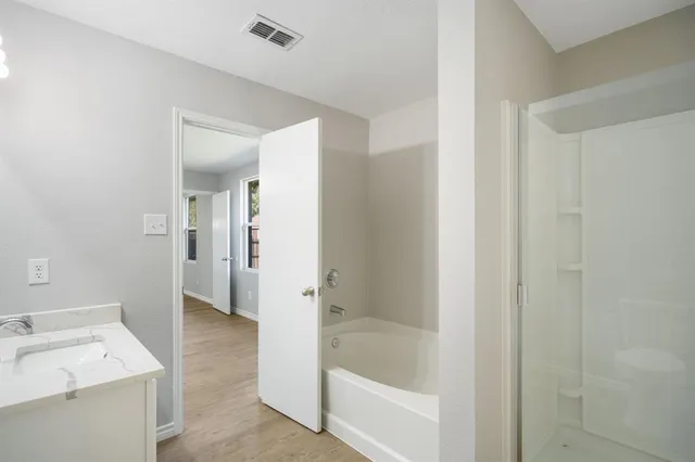 a bathroom with a tub sink and a mirror