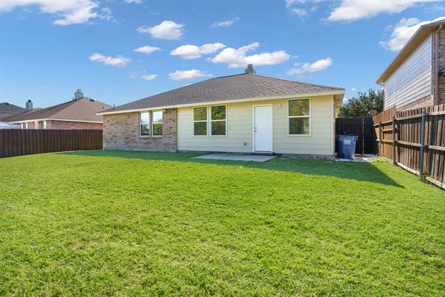 a view of a house with a yard and a patio