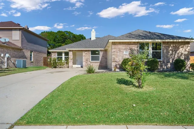 a front view of a house with a yard and potted plants