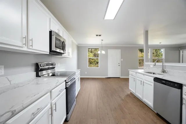 a kitchen with stainless steel appliances granite countertop a sink stove and cabinets
