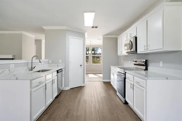 a kitchen with stainless steel appliances granite countertop a sink and cabinets