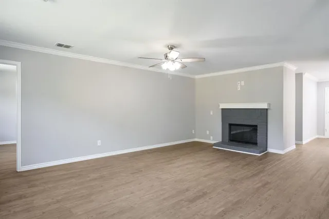 an empty room with fan and fireplace