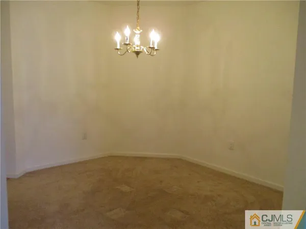 en empty room with a chandelier fan