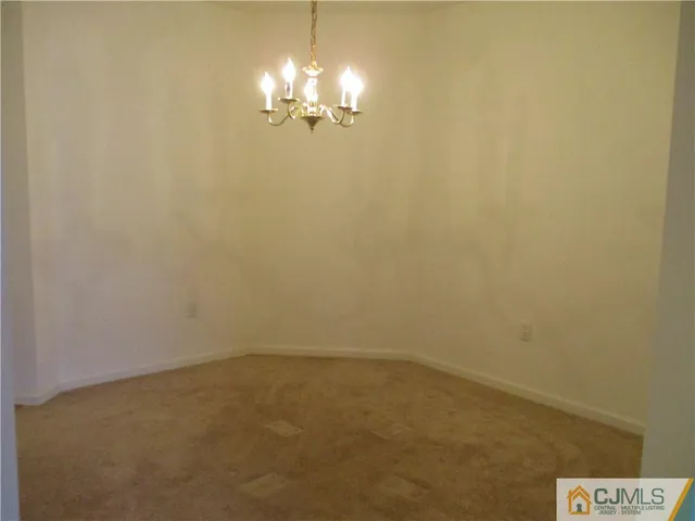 en empty room with a chandelier fan