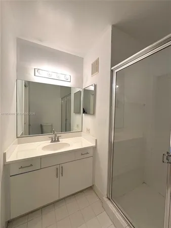 a bathroom with a double vanity sink mirror and shower