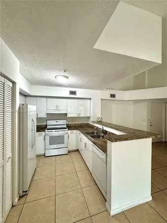 a kitchen with stainless steel appliances granite countertop a stove and a refrigerator
