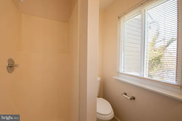 an empty room with a ceiling fan and window