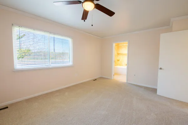 a spacious bathroom with a granite countertop toilet a sink and a mirror