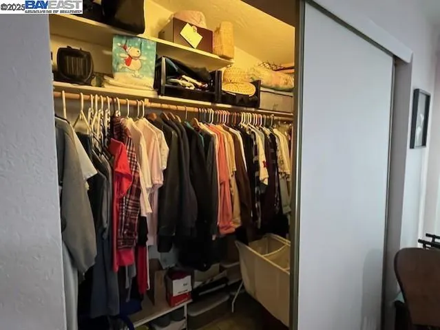 a view of walk in closet with clothes and shoes