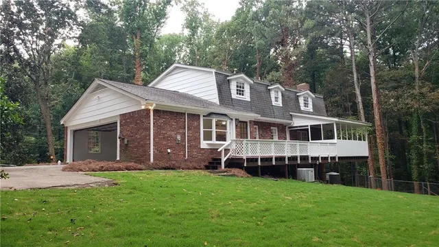 a front view of a house with a garden and yard