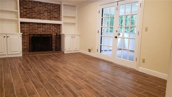 an empty room with wooden floor and a fireplace