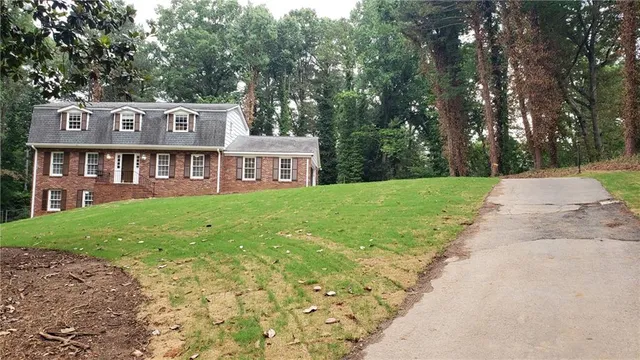 a view of a house with a yard and sitting area