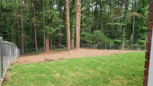 a view of a backyard with a wooden fence