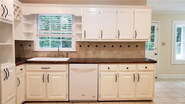 a kitchen with granite countertop white cabinets and white appliances
