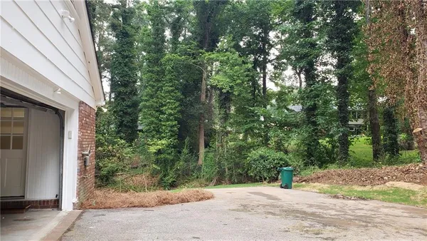 a backyard of a house with large trees and outdoor seating