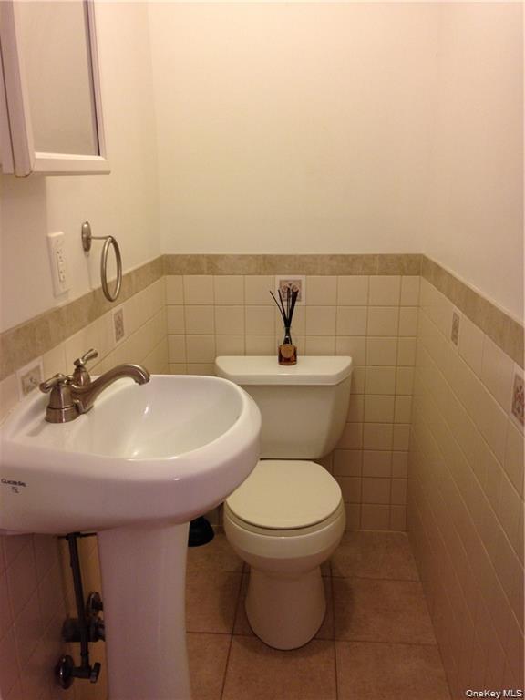 86 Brown Road Scarsdale, NY 10583 - Photo 4 of 17 a bathroom with a sink a toilet and mirror