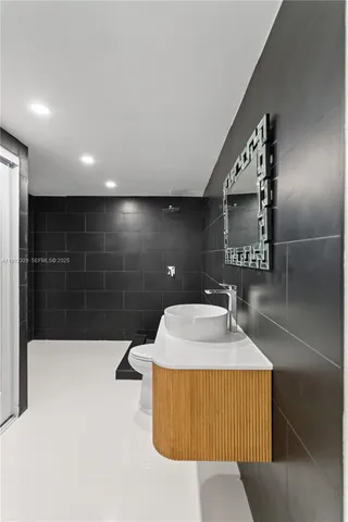 a bathroom with a toilet a sink and mirror