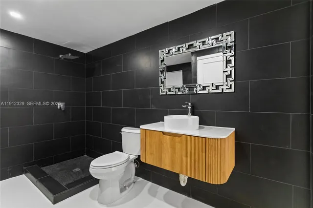 a bathroom with a toilet a sink and mirror