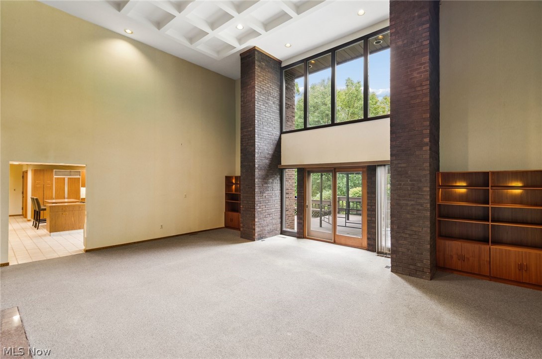 200 Hampshire Road Akron, OH 44313 - Photo 5 of 50 Two-story living area with coffered ceiling, floor-to-ceiling windows, and exposed brick columns