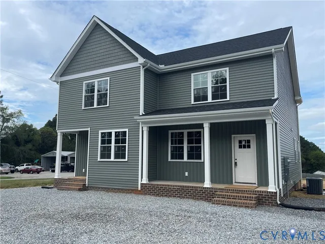 a view of house with yard and trees in the background