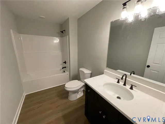 an empty room with wooden floor and window