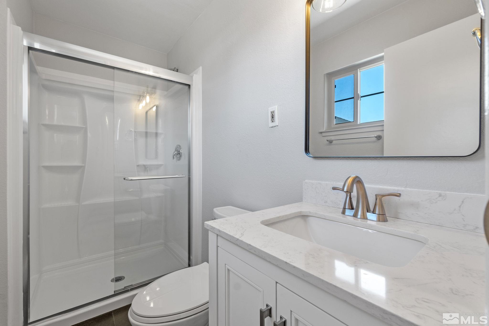 1685 Clemson Road Reno, NV 89502 - Photo 18 of 32 a bathroom with a sink a mirror a toilet and shower