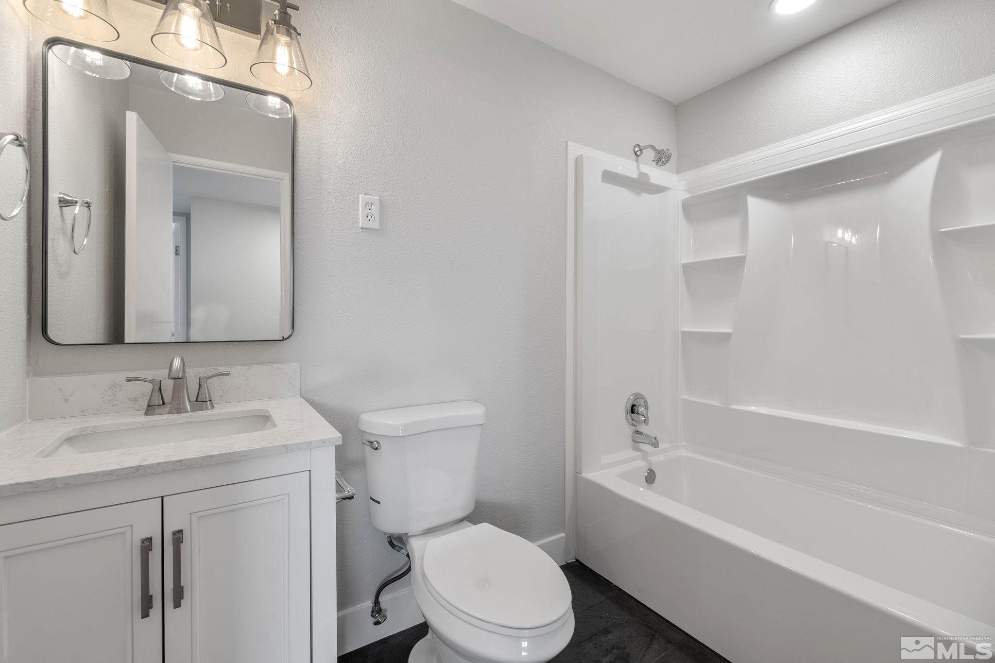 1685 Clemson Road Reno, NV 89502 - Photo 21 of 32 a bathroom with a bathtub shower sink vanity mirror and toilet