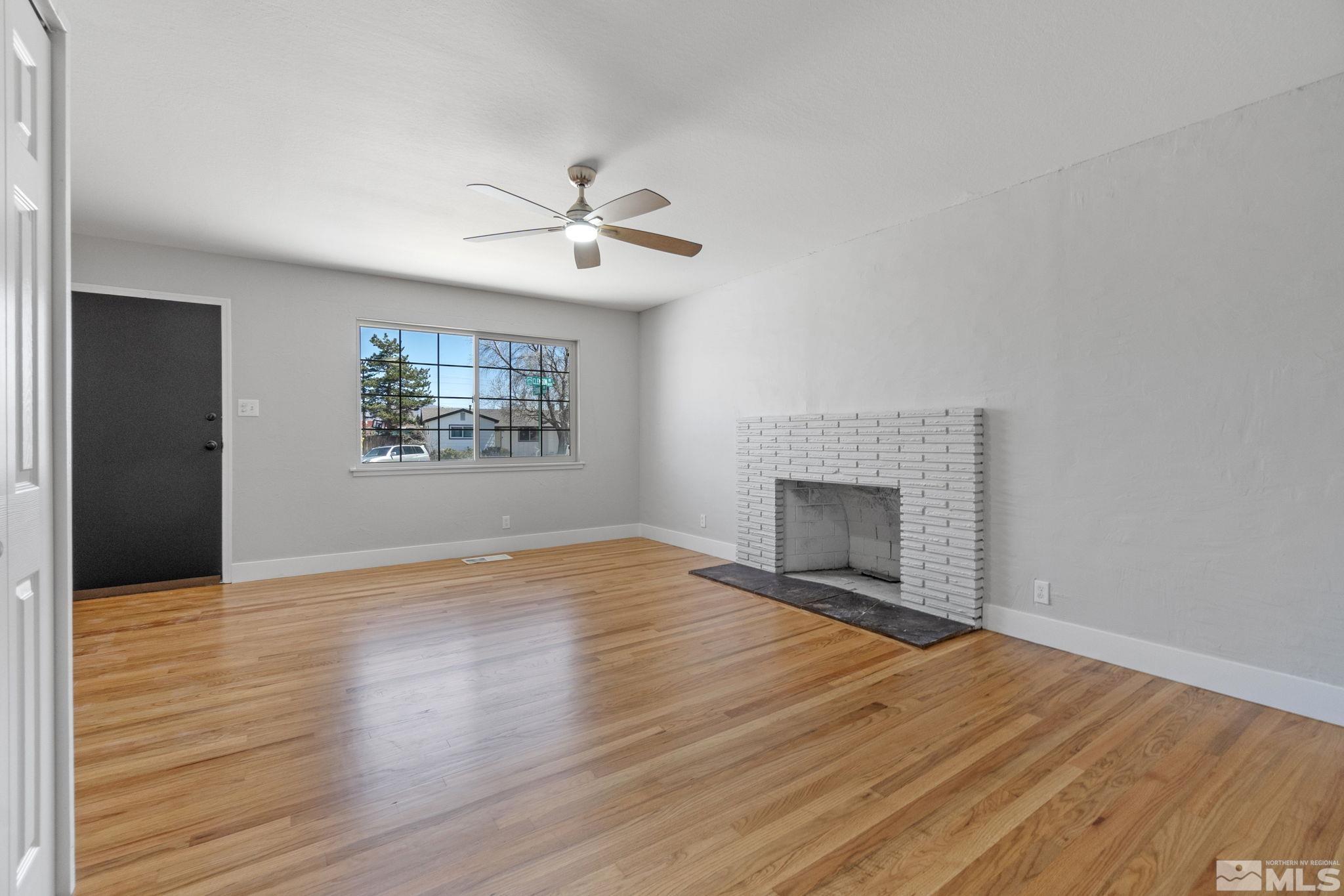 1685 Clemson Road Reno, NV 89502 - Photo 3 of 32 a view of empty room with wooden floor and fireplace
