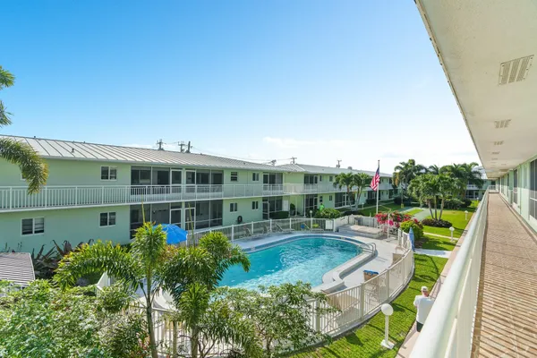 a view of a house with backyard sitting area and swimming pool
