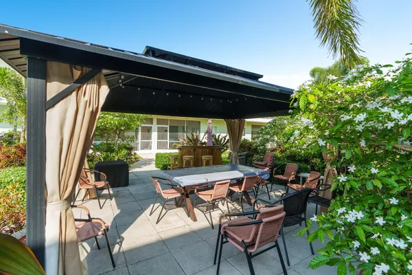 a view of a chair and table in backyard of the house