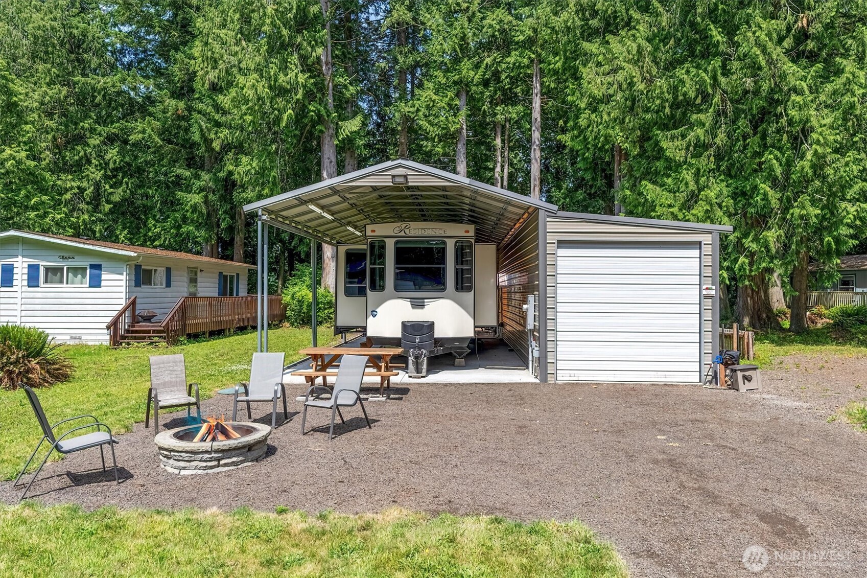 304 Winston Creek Road, Unit B10L3 Mossyrock, WA 98564 - Photo 3 of 30 a view of a patio with table and chairs under an umbrella with wooden fence