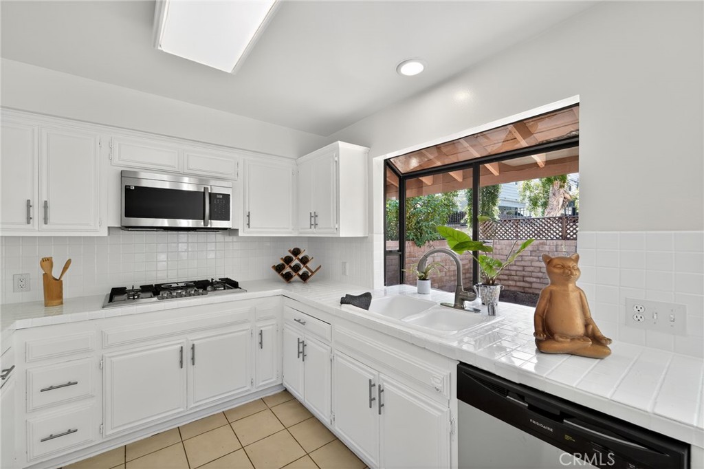 20254 Stagg Street Winnetka, CA 91306 - Photo 14 of 27 a kitchen with stainless steel appliances white cabinets and a granite counter tops