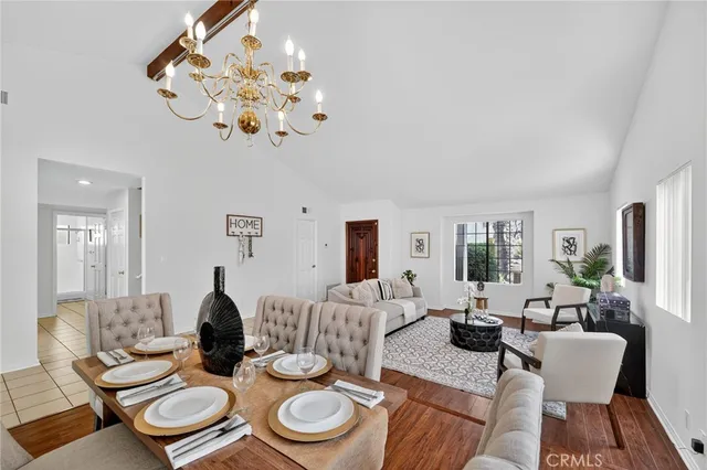 a living room with furniture a dining table and a chandelier