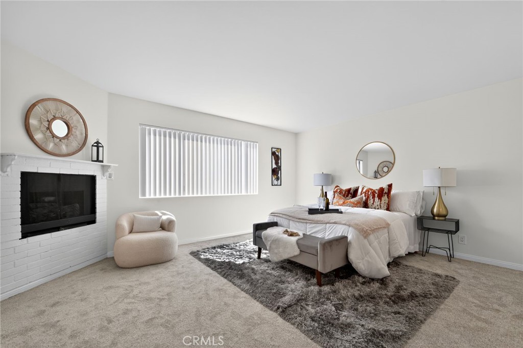 20254 Stagg Street Winnetka, CA 91306 - Photo 22 of 27 a bedroom with a bed and a fireplace