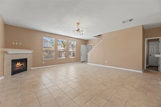 a view of an empty room with a fireplace and a window