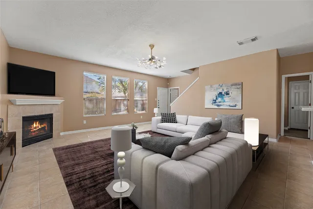 a living room with furniture a fireplace and a flat screen tv