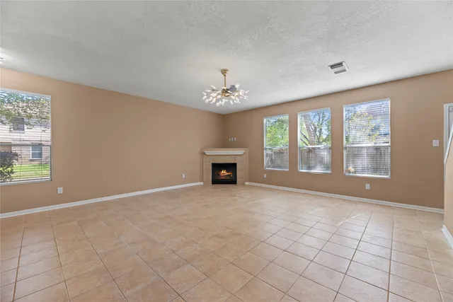 an empty room with windows and fireplace